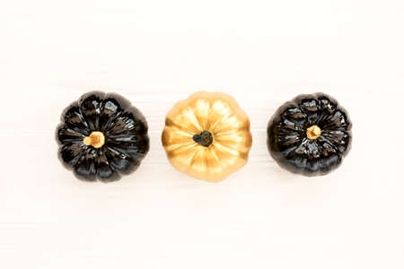 Stylish Halloween decorations. Decorative pumpkin black and gold Halloween isolated on white background. Flat lay, top view.の写真素材
