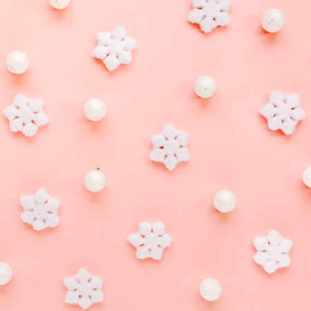 Holiday texture with white christmas snowflakes on pink background. Christmas composition, wallpaper. Flat lay, top viewの写真素材