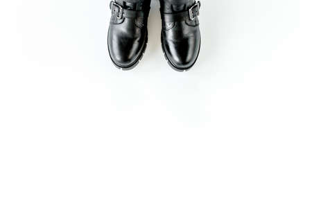 Black female boots on white background. Flat lay, top view minimal background. Fashion blog or magazine concept.の写真素材