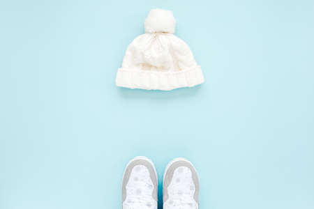 White women winter the boots and hat, glasses isolated on blue background. Flat lay, top view trendy fashion feminine background. Beauty blog concept.の写真素材