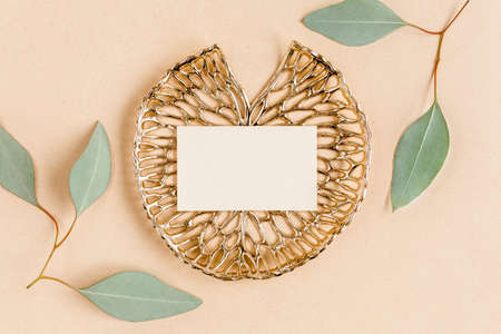 Mockup invitation, blank greeting card and green leaves eucalyptus. Flat lay, top view.