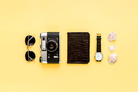 Traveler accessories on yellow background with camera and sunglasses. Flat lay, top view. Summer...