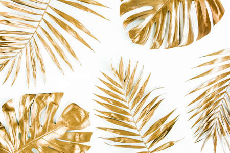 Gold tropical palm leaves Monstera on white background. Flat lay, top view minimal concept.の写真素材