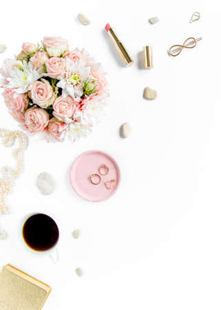 Stylized womens desk, office desk. Workspace with, laptop, roses, clipboard. Womens fashion accessories on white background. Flat lay Top viewの写真素材