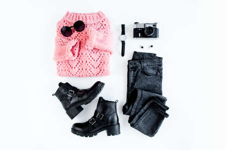 Women fashion clothes and accessories on white background top view. Flat lay female style look with warm sweater, jeans, boot, glasses. Top view.の写真素材