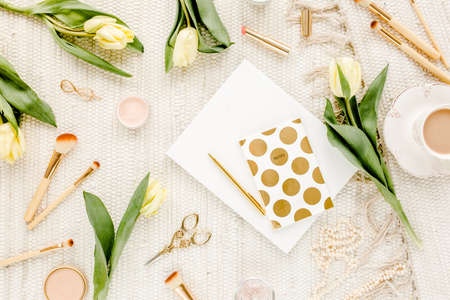 Female workspace with yellow tulip flowers, womens fashion golden accessories, diary, glasses on white background. Flat lay. Top view feminine.の写真素材