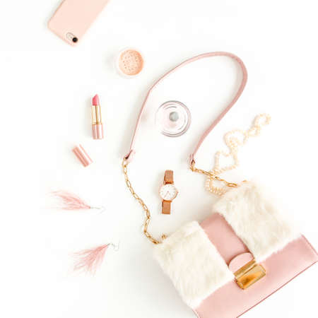 Womens pink bag with fashion trendy accessories: watch, perfume, phone, lipstick, earrings on white background. Flat lay, top viewの写真素材