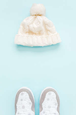 White women winter the boots and hat, glasses isolated on blue background. Flat lay, top view trendy...