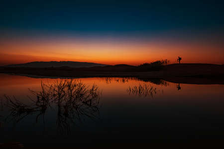 Sunrise at the leak with reflection on the waterの写真素材