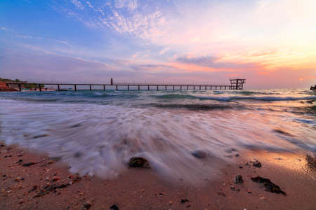 Sun rise at the broken bridge with slow shutter speed on the water.の写真素材