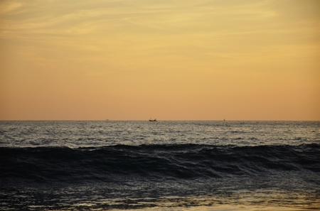 A ship sailing by at a distance in the Indian Ocean at Sunset の写真素材