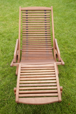 A wooden sunbed on green grassの写真素材
