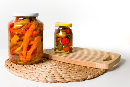 Two jars of paprika on cuting board