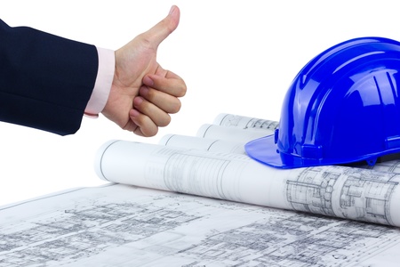 business hand with thumb up over construction plan and hard hat isolated on white back groundの写真素材