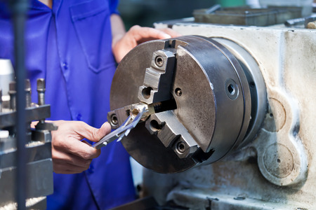 Milling machine operator working in factory workshop