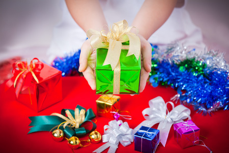 Celebration theme with merry christmas & happy new year gifts, lady hand showing beautiful gift boxの写真素材