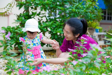 Happy asian woman and little girl relaxing at home back yard and sun light in holidayの写真素材