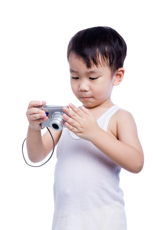 Portrait of asian boy in a white singlet interesting digital compact photo camera with good intentionsの写真素材
