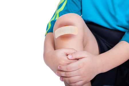 Child knee with a plaster (for wounds) and bruise, Isolated on white backgroundの写真素材