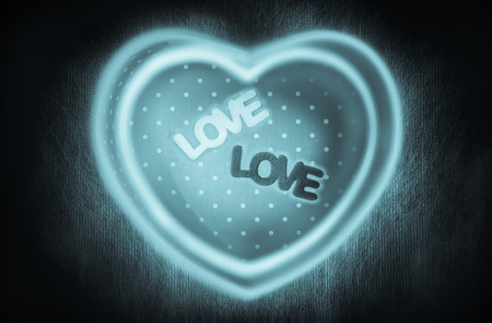 Heart-shaped gift box and two text \"love\" middle box with double magic heart-shape neon or  fluorescent light lines on dark background low key picture style for a Valentineの写真素材