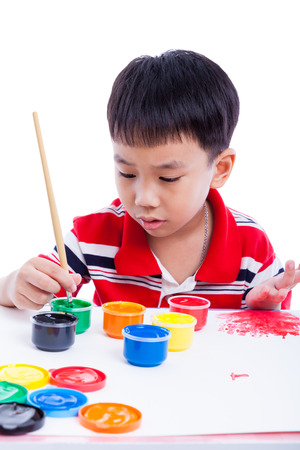 Little asian (thai) boy draw image using multicolored drawing instruments (watercolor paints, paintbrush), creativity concept, isolated on white background, studio shotの写真素材