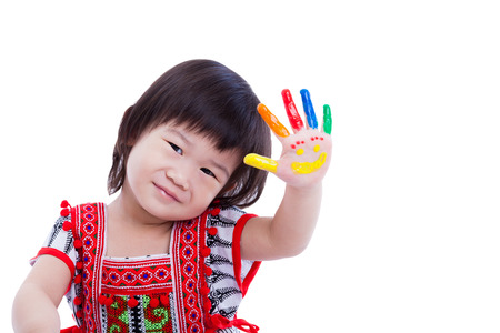 Adorable little asian (thai) girl painting her palm, colorful right hand painted with smiling face, happy childhood, some space for input text message. Isolated on white background, studio shotの写真素材