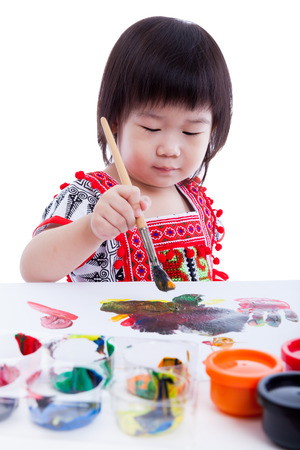 Little asian (thai) girl painting and using multicolored drawing instruments, creativity learning education concept, Isolated on white background, studio shotの写真素材