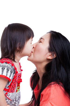 Happy family - Mother and little asian girl kissing together, on white background. Mothers Day celebrationの写真素材