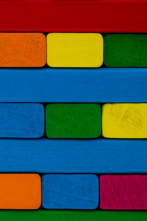 Square shape colorful background in red, yellow, green, orange, pink and blue created of wooden toy blocks. Wooden color toy blocks backgroundの写真素材