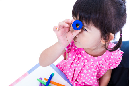 Little asian girl playing and creating toys from play dough. Child show her works from clay, over white background. Strengthen the imagination of childの写真素材