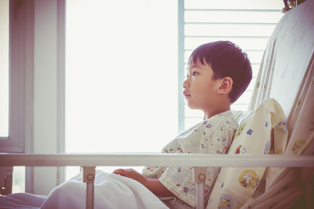 Illness asian child admitted at modern and comfortable equipped hospital room. Health care and people concept. Vignette and vintage style.の写真素材