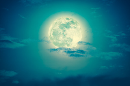 Attractive photo of a nighttime green sky with clouds and bright full moon. Nightly sky with large moon. Outdoors at night. Cross process and vintage tone effect. The moon were NOT furnished by NASA.の写真素材