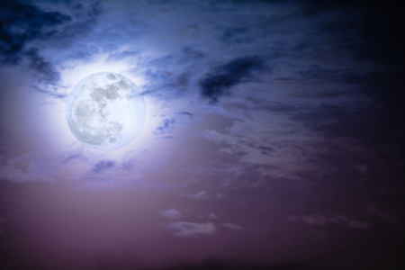 Attractive photo of background nighttime sky with clouds and bright full moon with shiny. Nightly sky with beautiful full moon behind cloud. Outdoors at night. The moon were NOT furnished by NASA.の写真素材