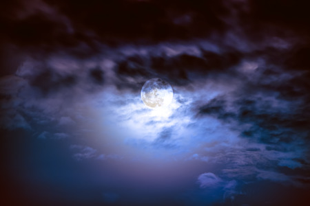 Attractive photo of background nighttime sky with clouds and bright full moon with shiny. Nightly sky with beautiful full moon behind cloud. Outdoors at night. The moon were NOT furnished by NASA.の写真素材