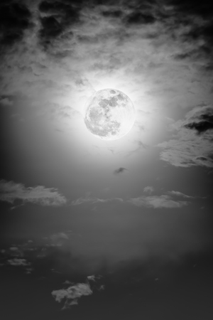 Background of nighttime sky with cloud and full moon with shiny. Natural beauty at night with moon behind cloud in black and white style. Vintage effect tone. The moon were NOT furnished by NASA.の写真素材