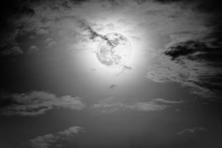 Background of nighttime sky with cloud and full moon with shiny. Natural beauty at night with moon behind cloud in black and white style. Vintage effect tone.の写真素材
