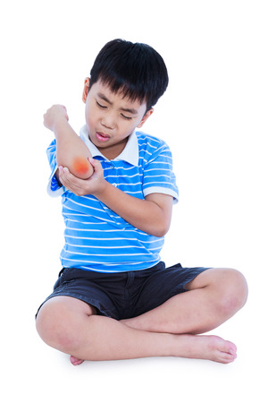 Full body of asian child injured at elbow. Sad boy groaning and looking at bruise with a painful gesture. Isolated on white background. Human health care and problem concept.の写真素材