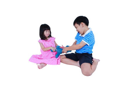 Quarreling conflict of child. Asian girl has problem between brother and crying. Sibling wrest with teddy bear. Relationships difficulties in family concept. Isolated on white background. Studio shot.の写真素材