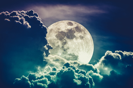 Super moon. Attractive photo of background night sky with cloudy and bright full moon. Nightly sky with beautiful full moon behind clouds. Cross process. The moon were NOT furnished by NASA.の写真素材