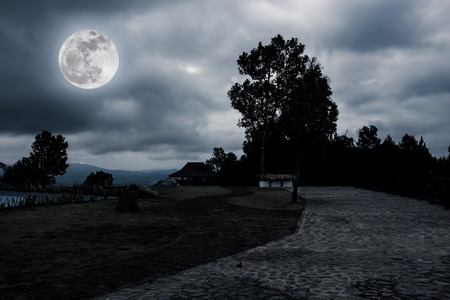 Night sky and super moon with curvy roadway at view point. Landscape of moonlight in the midst of beauty nature. Dark tone.The moon were NOT furnished by NASA.の写真素材