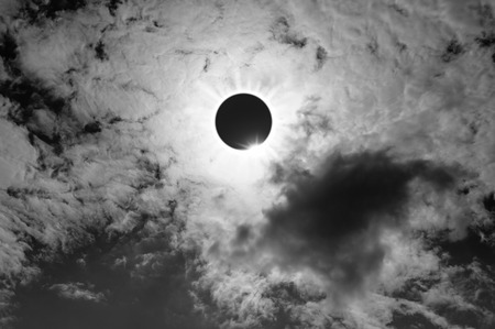 Scientific natural phenomenon. The Moon covering the Sun. Total solar and lunar eclipse with diamond ring effect glowing on sky. Beautiful nature and serenity landscape. Black and white style.の写真素材