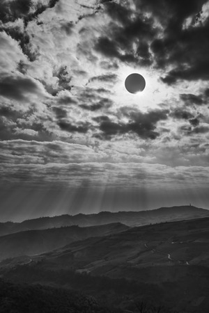 Amazing scientific natural phenomenon. The Moon covering the Sun. Total solar eclipse with diamond ring effect glowing on sky above mountain range. Serenity nature background.の写真素材