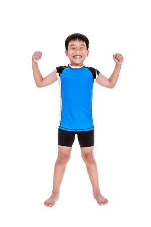 Full body of children powerful. Asian strong and confident boy cyclist is flexing biceps muscle fitness exercise and smiling happily. Healthy child lifestyle. Isolated on white background. Studio shot.の写真素材