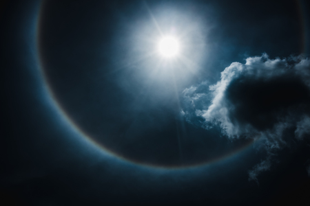 Moon halo phenomenon. Beautiful night landscape of dark blue sky and bright ring around the moon...