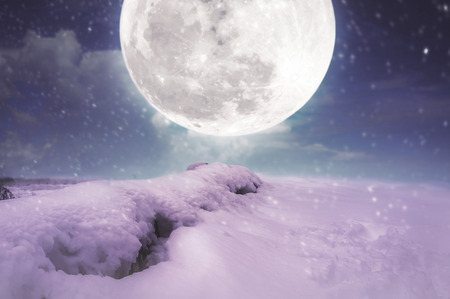 Photo Manipulation. Landscape at snowfall with supermoon. Majestic night with bright full moon on blue sky. Snow covered the ground in winter season. Serenity nature background. The moon taken with my camera.の写真素材