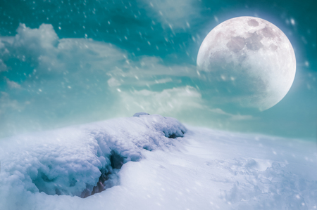 Photo Manipulation. Landscape at snowfall with supermoon. Majestic night with full moon on sky. Snow covered the ground in winter season. Serenity nature background. The moon taken with my camera.の写真素材