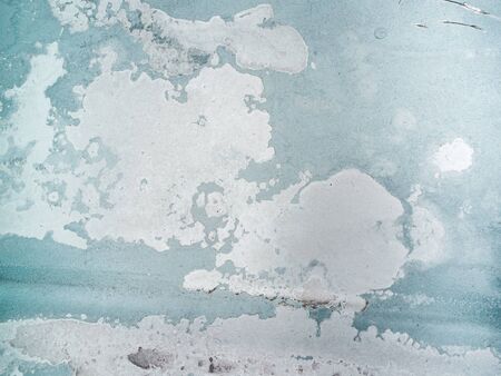 Worn rusty metal surface with green paint flaking and cracking texture background.の写真素材