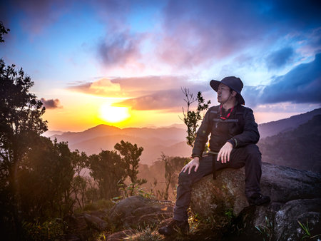 Traveler man enjoying serenity view of mountains at sunrise. Beautiful of natural landscape with swinging in the morning mist. Lifestyle hiking concept summer vacations.の写真素材