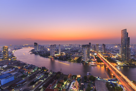 Cityscape of River in Bangkok city with high office building in night time
