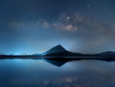 Night sky with stars and The Milky Way is above the mountain and reflection on the water (Lam Isu Reservoir) Kanchanaburi, Thailandの写真素材
